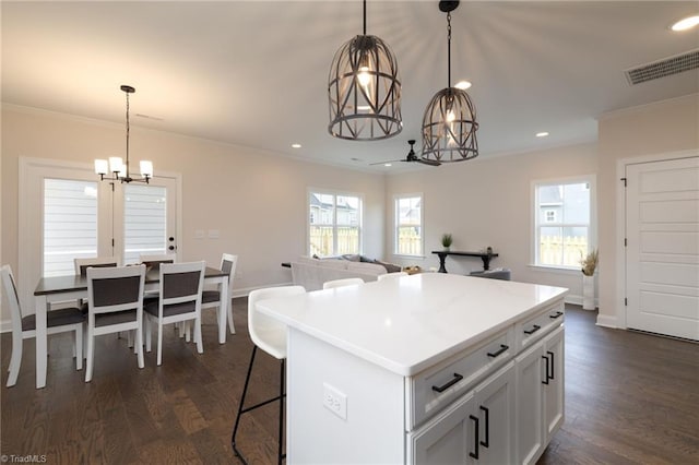 1815 Cleburne Ter, Kernersville, NC 27284 - kitchen with a chandelier, crown molding, dark wood-style flooring, a center island, and baseboards
