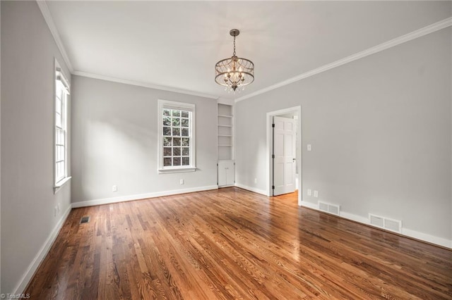 unfurnished room featuring an inviting chandelier, visible vents, and ornamental molding