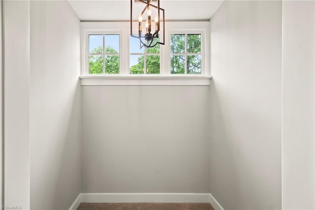 unfurnished dining area with a chandelier, baseboards, and plenty of natural light