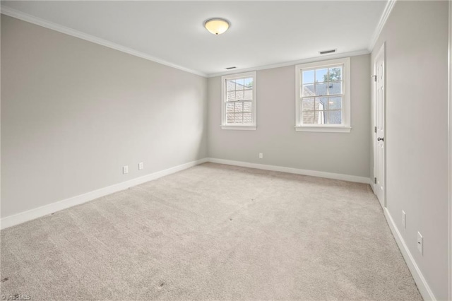 spare room with baseboards, visible vents, light colored carpet, and crown molding