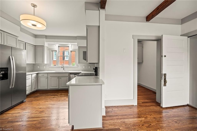 kitchen with beamed ceiling, gray cabinetry, stainless steel appliances, and decorative backsplash