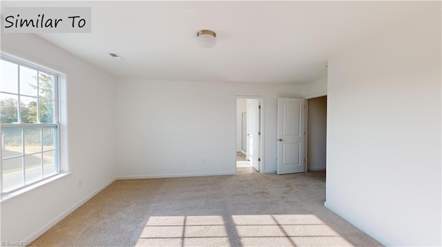 unfurnished room with plenty of natural light and light carpet