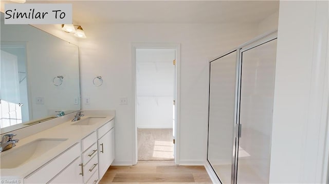 bathroom featuring vanity, wood-type flooring, and a shower with shower door