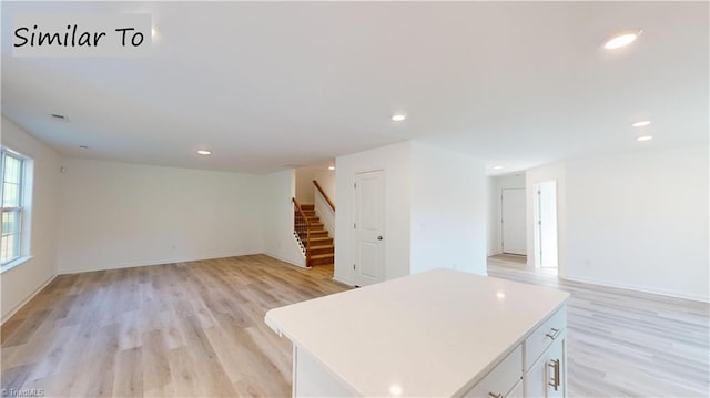 kitchen featuring a center island, light hardwood / wood-style floors, and white cabinetry