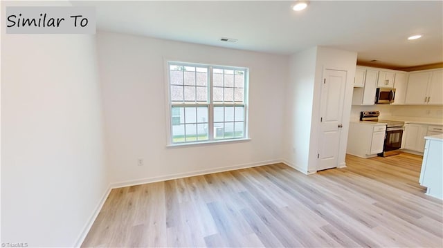 kitchen with white cabinetry, light hardwood / wood-style flooring, and electric range oven