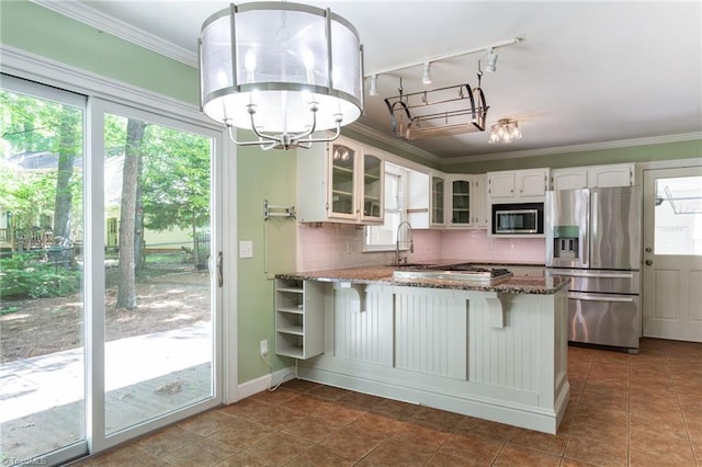 4602 Forest Glen Rd, Greensboro, NC 27410 - kitchen with stainless steel appliances, a chandelier, a peninsula, dark stone counters, and glass insert cabinets