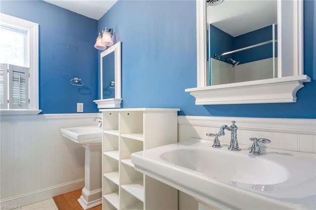 4602 Forest Glen Rd, Greensboro, NC 27410 - full bathroom with wainscoting, a sink, wood finished floors, and a shower