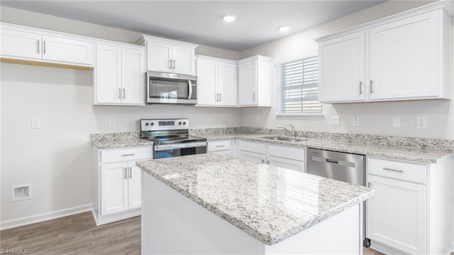 821 Merriweather Dr, King, NC 27021 - kitchen featuring stainless steel appliances, a sink, baseboards, white cabinets, and light wood-style flooring