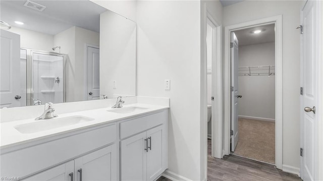 821 Merriweather Dr, King, NC 27021 - full bath featuring double vanity, wood finished floors, a shower stall, a spacious closet, and baseboards