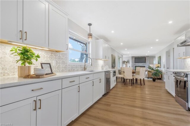 4566 Fork Rd, Norwood, NC 28128 - kitchen with stainless steel appliances, white cabinetry, light wood finished floors, recessed lighting, and tasteful backsplash