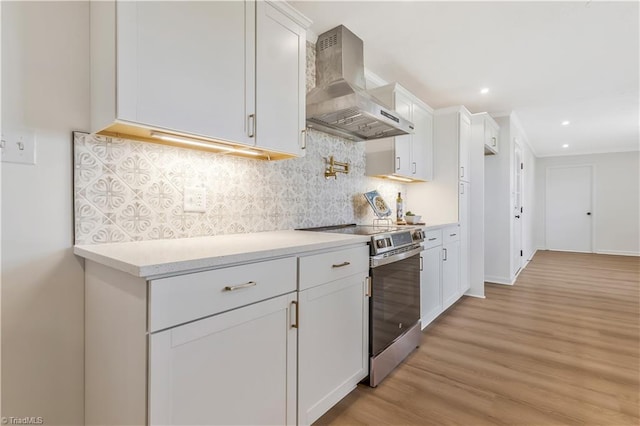 4566 Fork Rd, Norwood, NC 28128 - kitchen featuring wall chimney range hood, electric stove, white cabinets, light wood-type flooring, and light countertops