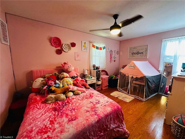 bedroom with dark hardwood / wood-style flooring and ceiling fan