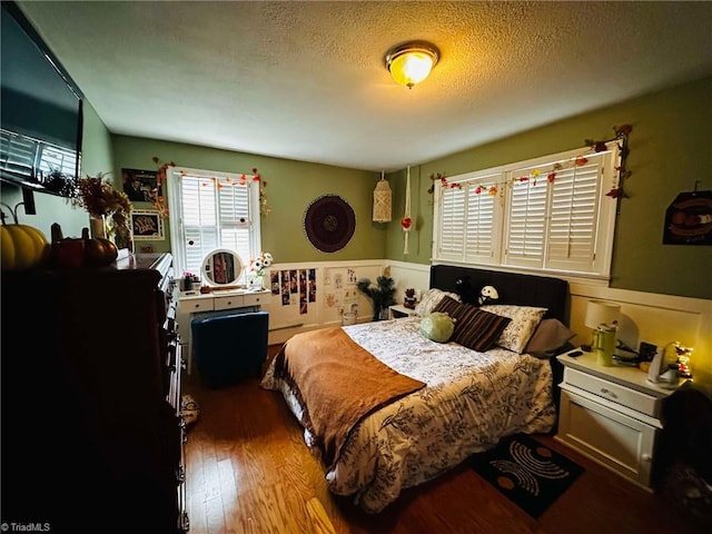 bedroom with wood-type flooring and a textured ceiling