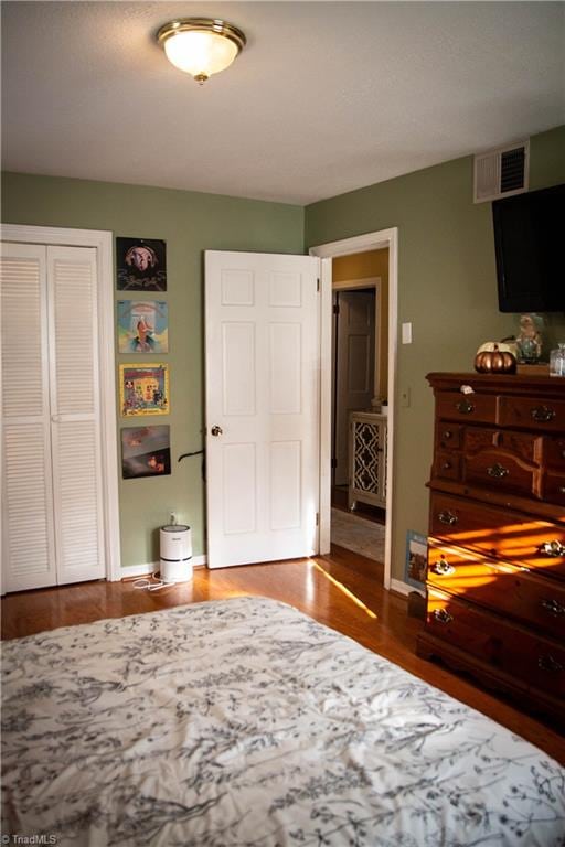 bedroom with a closet and dark hardwood / wood-style floors