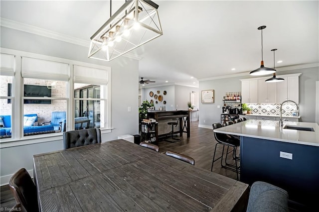 dining space with ceiling fan, ornamental molding, dark hardwood / wood-style floors, and sink