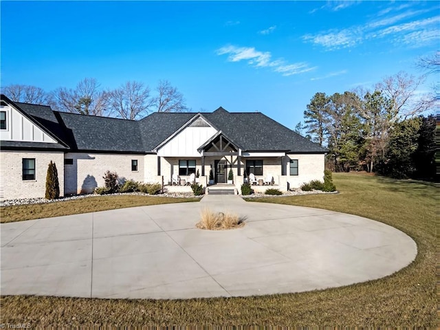 modern farmhouse style home featuring a front yard and covered porch