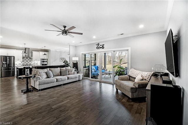 living room featuring dark wood-type flooring, ceiling fan, and crown molding