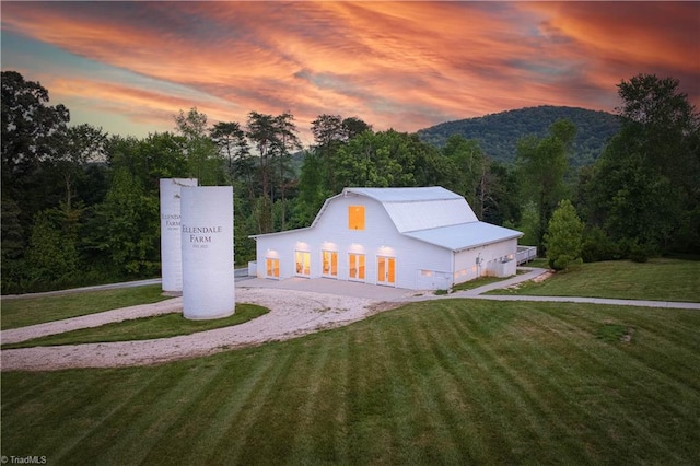 view of front of house with a lawn and a mountain view