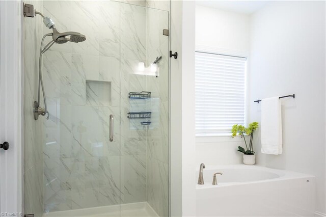 bathroom featuring a shower stall and a garden tub