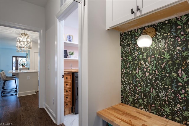 mudroom with washer / clothes dryer, dark wood-type flooring, a sink, and an inviting chandelier