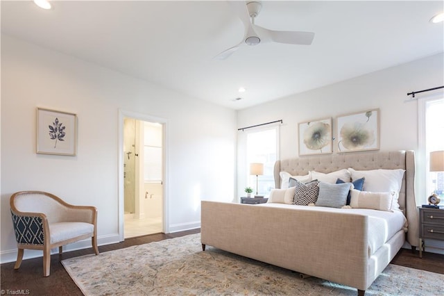 bedroom with baseboards, connected bathroom, recessed lighting, and dark wood-style flooring