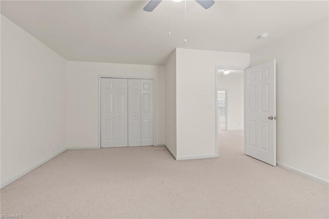 unfurnished bedroom with light carpet, a closet, and ceiling fan