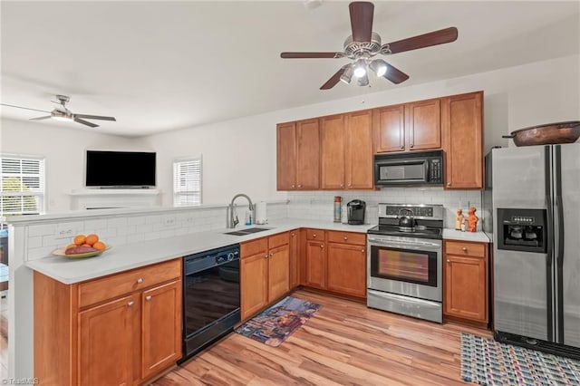 kitchen with sink, light hardwood / wood-style flooring, black appliances, backsplash, and ceiling fan