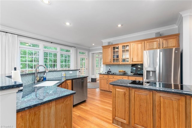 kitchen with sink, light hardwood / wood-style flooring, decorative backsplash, appliances with stainless steel finishes, and ornamental molding