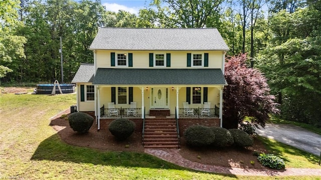 view of front of property featuring covered porch and a front yard