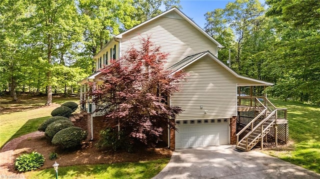 view of side of property featuring an attached garage, a lawn, stairway, and concrete driveway