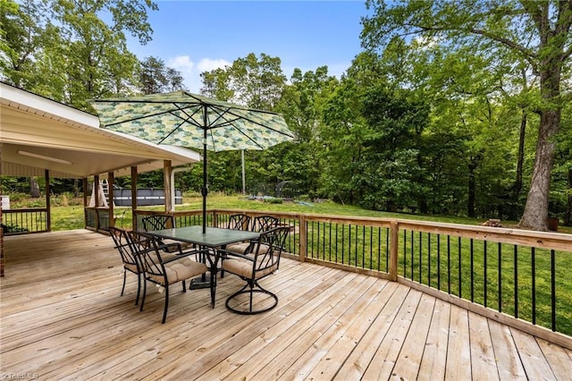 wooden terrace with a lawn and outdoor dining space