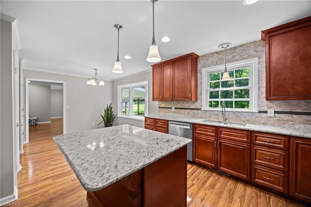 kitchen featuring a kitchen island, tasteful backsplash, dishwasher, a sink, and ornamental molding