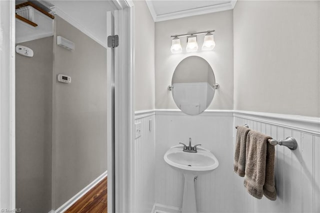bathroom with ornamental molding, wainscoting, and wood finished floors