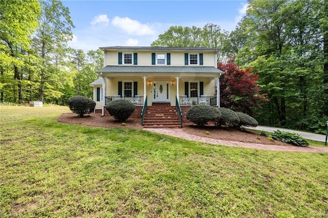 colonial house with stairs, a porch, and a front yard
