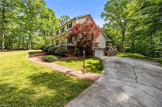 view of front of property with an attached garage, driveway, stairway, and a front yard