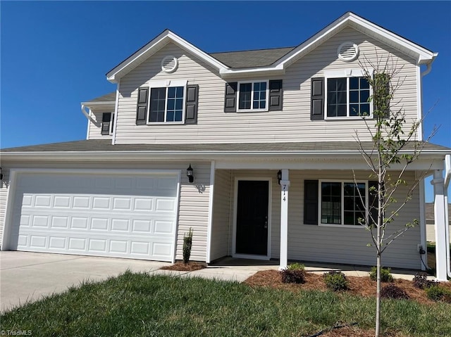 traditional-style home featuring an attached garage, covered porch, and concrete driveway