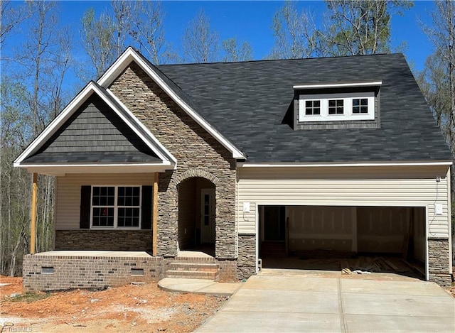 craftsman house with a garage, crawl space, driveway, and stone siding