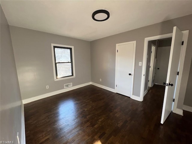 unfurnished bedroom featuring dark hardwood / wood-style flooring