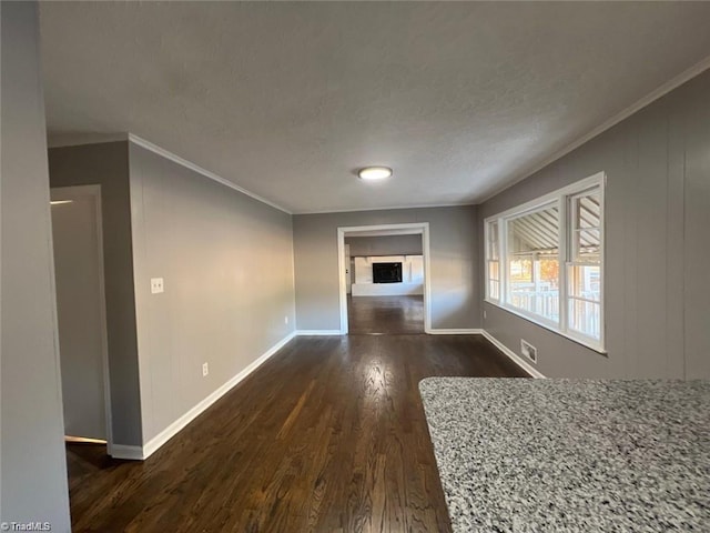 unfurnished living room with ornamental molding, a textured ceiling, and dark hardwood / wood-style floors