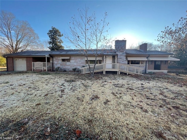 rear view of house with a wooden deck and a garage