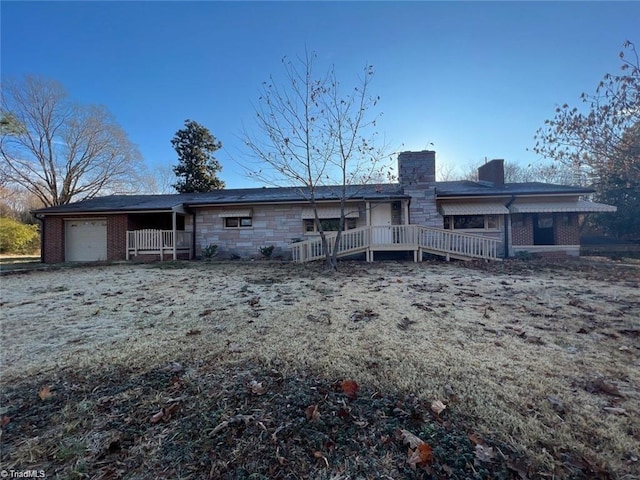 back of house featuring a wooden deck and a garage