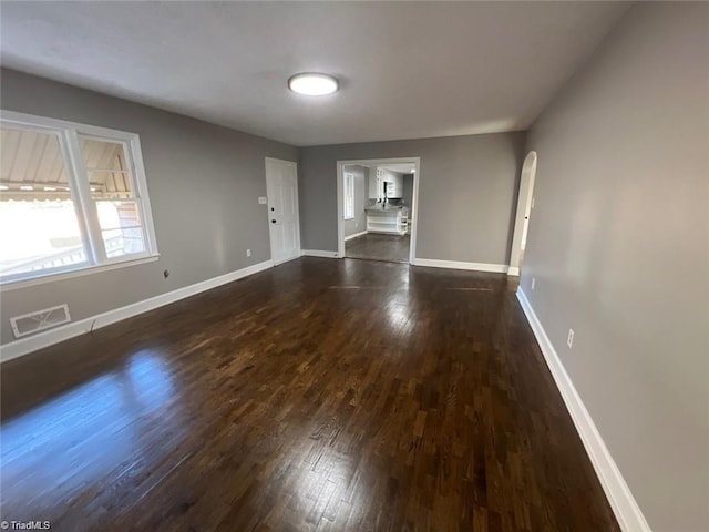 unfurnished living room with dark wood-type flooring