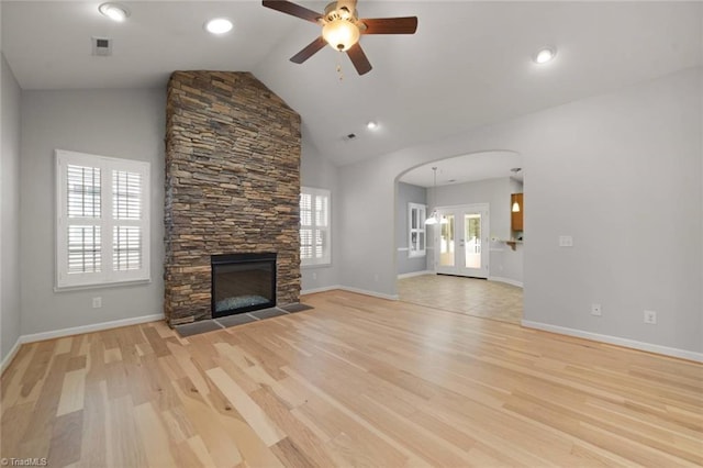 unfurnished living room featuring arched walkways, ceiling fan, visible vents, and light wood-style flooring