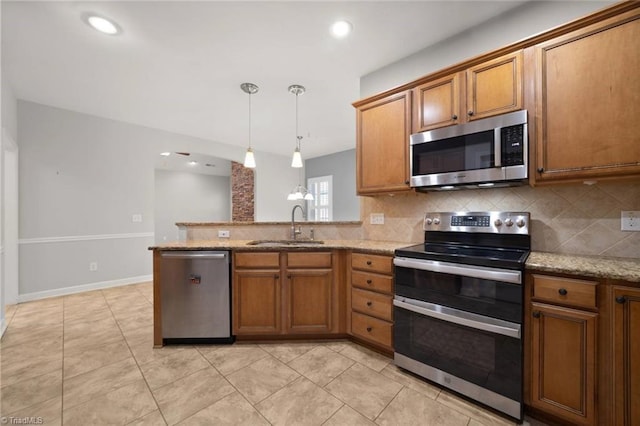 kitchen with a sink, appliances with stainless steel finishes, and brown cabinets