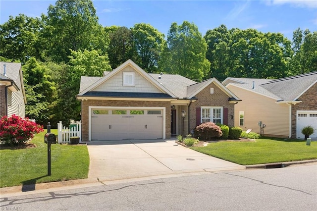 view of front of property with an attached garage, concrete driveway, a front lawn, and brick siding