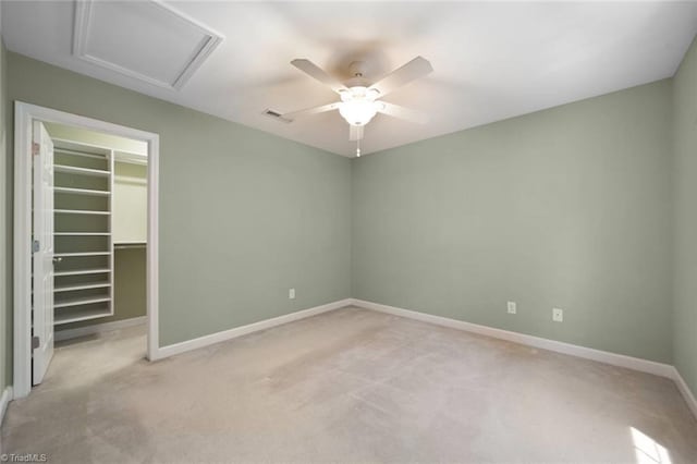 unfurnished bedroom featuring visible vents, attic access, baseboards, and light colored carpet