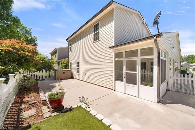 rear view of house featuring a patio, a fenced backyard, and a sunroom