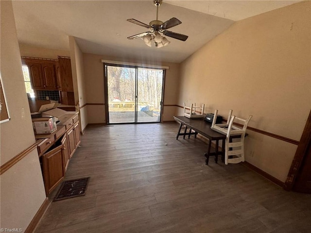 dining space with visible vents, baseboards, lofted ceiling, ceiling fan, and dark wood-style flooring