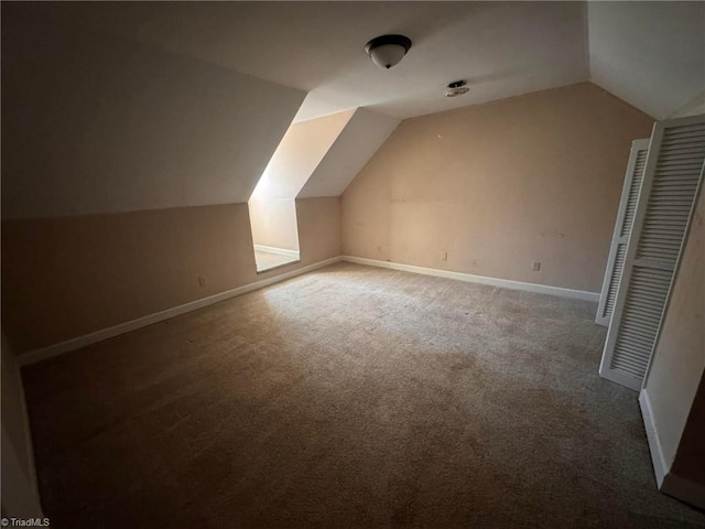 additional living space featuring lofted ceiling, carpet, and baseboards