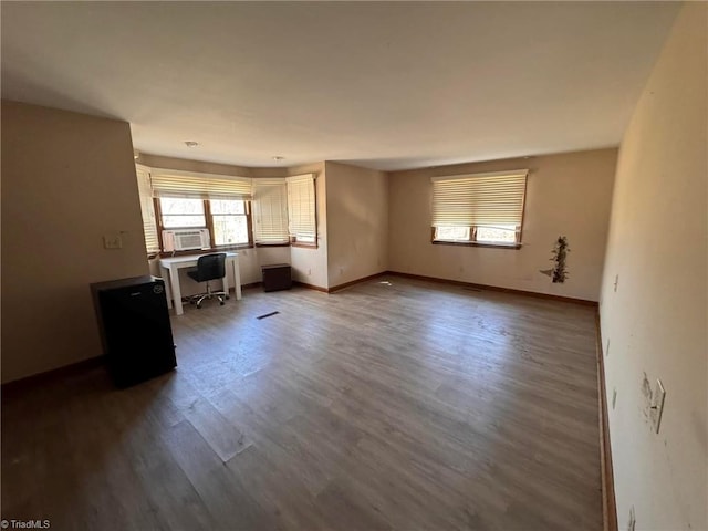 unfurnished living room with visible vents, cooling unit, wood finished floors, and baseboards